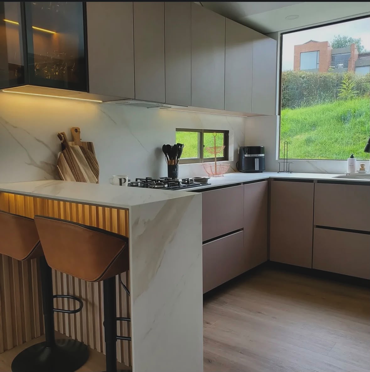 Cozinha planejada com bancada em mármore e painel ripado